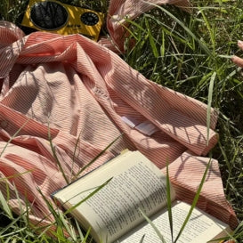 Ropa orgánica sobre grama y un libro encima