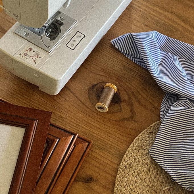 Maquina de coser al lado de una prenda de ropa